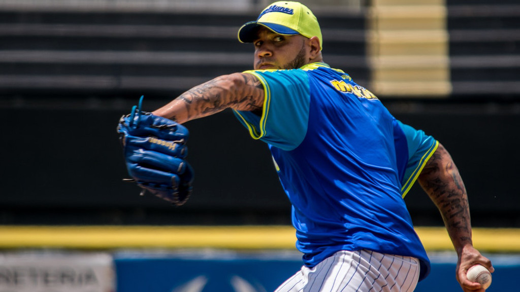 A right-handed pitcher in his windup, about to deliver a pitch